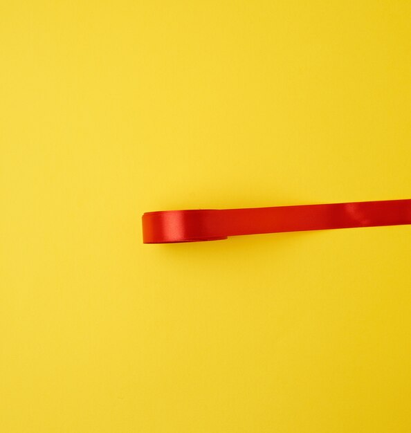 Photo red silk ribbon on yellow