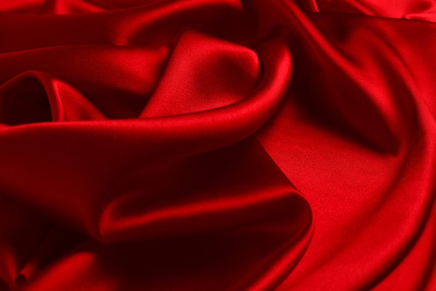 Red silk or satin luxury fabric texture can use as abstract background. Top view.