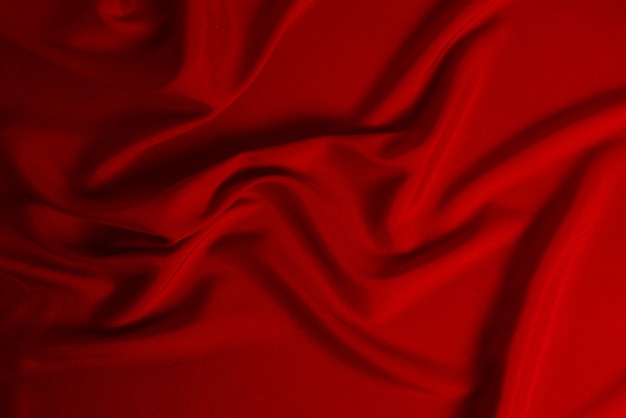 Red silk or satin luxury fabric texture can use as abstract background. Top view.