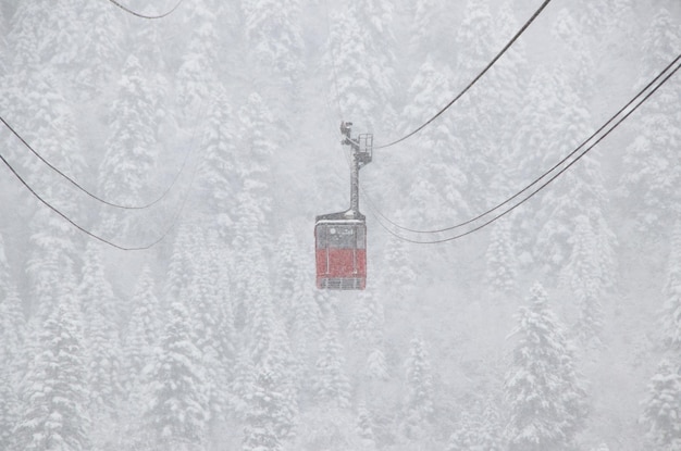 Red skilift cabine in the strong snowfall in the mountains of the Caucasus