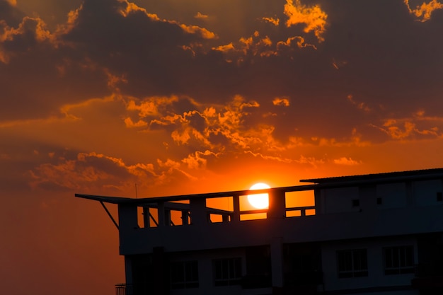 Photo red sky silhouette of a sunset with a building blocking it.