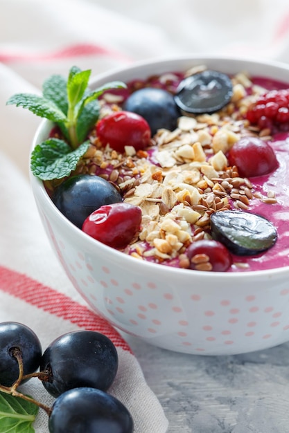 Red smoothie bowl with beets and black grapes