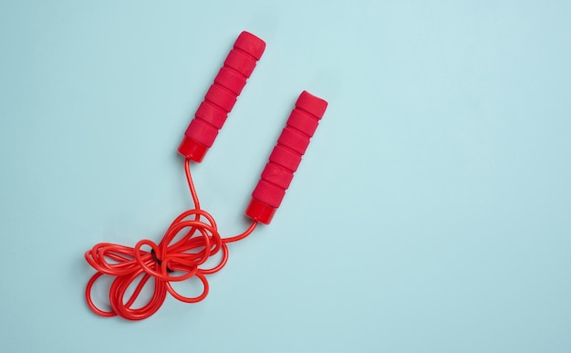 Red sports jump rope on a blue background top view