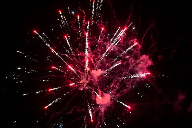 Red spots of fireworks in smoke on a black background Festive background