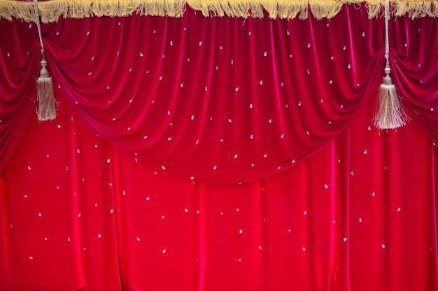 Red stage curtain with pleats and fringes