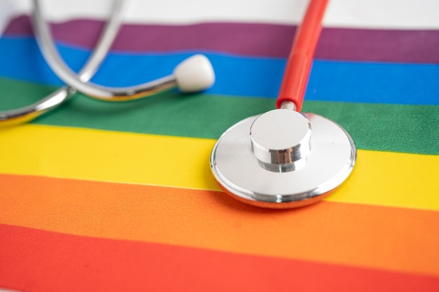 Red stethoscope on rainbow flag background symbol of LGBT pride month