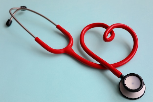 Red stethoscope with heart on blue modern background