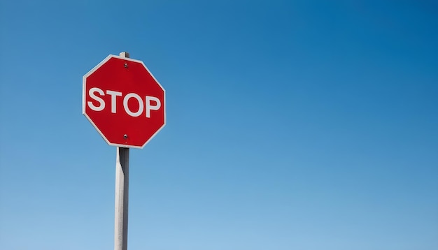 A red stop sign against a clear blue sky