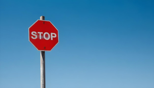 A red stop sign against a clear blue sky