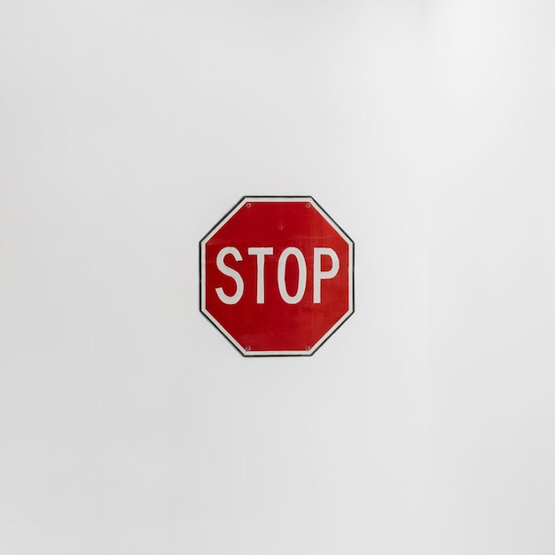 a red stop sign is shown against a white wall