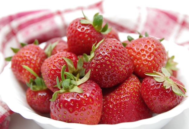 Red strawberries in a white bowl.