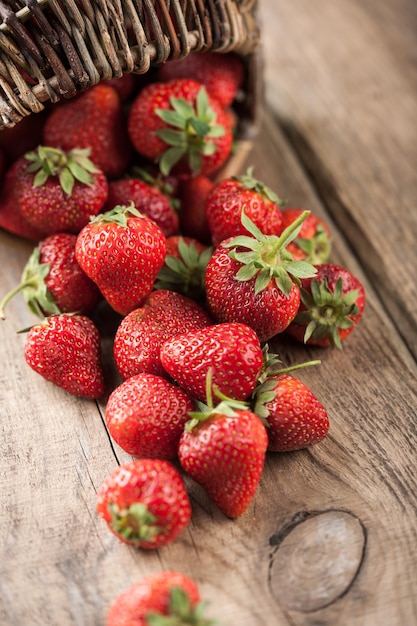 Red strawberry in the basket and on the table close-up