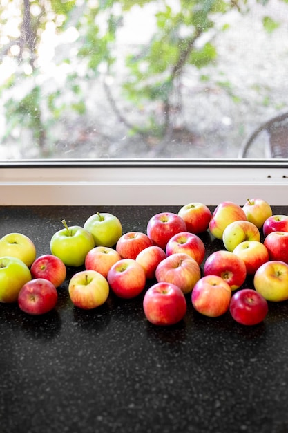 Red and striped apples on the windowsill Harvest of early apples on a summer day