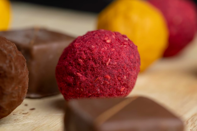 Red sweet candy in the shape of a ball on the table chocolate candy with berry flavor of red color