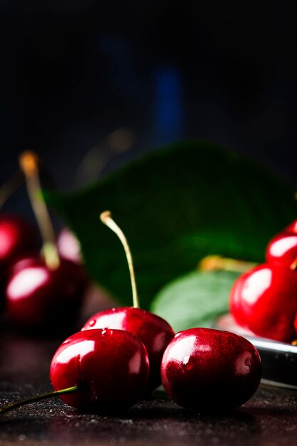 Red sweet cherries on brown table selective focus