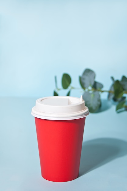 Red take away coffee cup and home plant