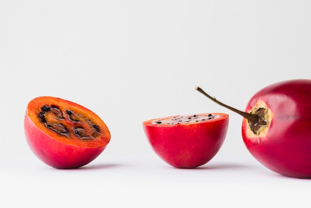 Red Tamarillo with two slices over white background slice over white background