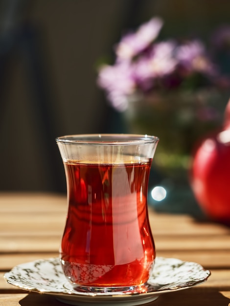 Red tea in a glass on a plate