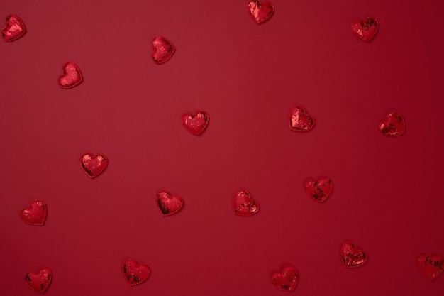 Red textile heart on red paper background