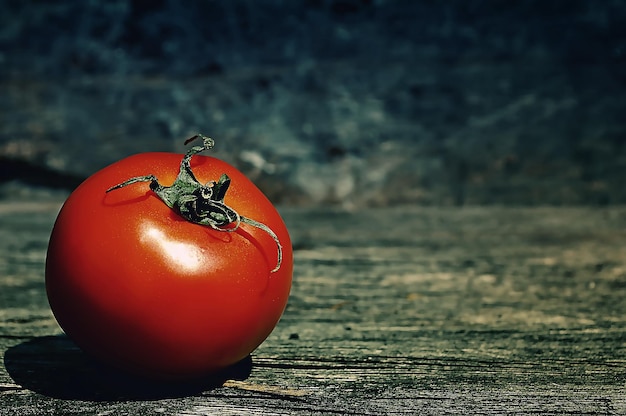 red tomato on textured wooden background