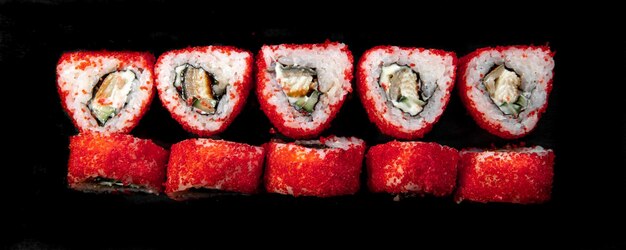 red triangular japanese rolls top view on a black background