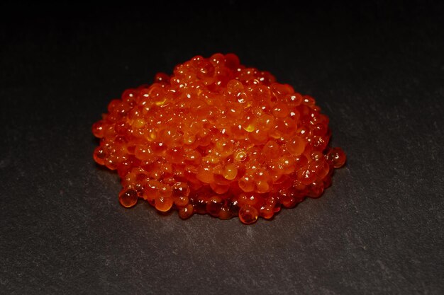 Red trout caviar on a black background