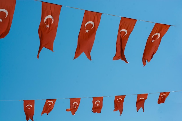 Red turkish flag with crescent and star waving against sky