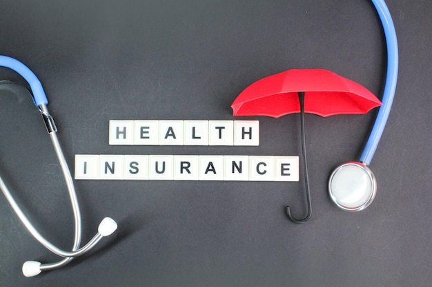 Red umbrella and stethoscope on a black background with the words health insurance