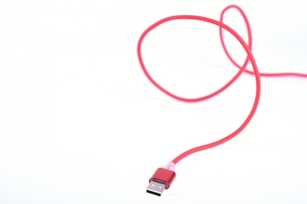 Red USB cable for smartphone charge isolated.