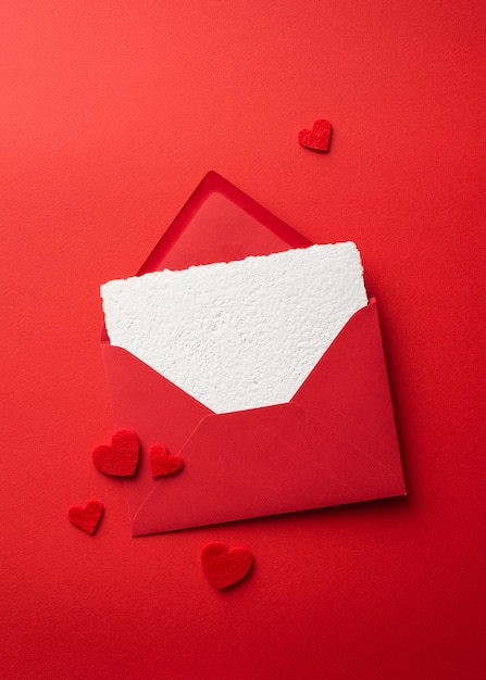 Red Valentines Day background with greeting card template with envelope and hearts. Top view with copy space