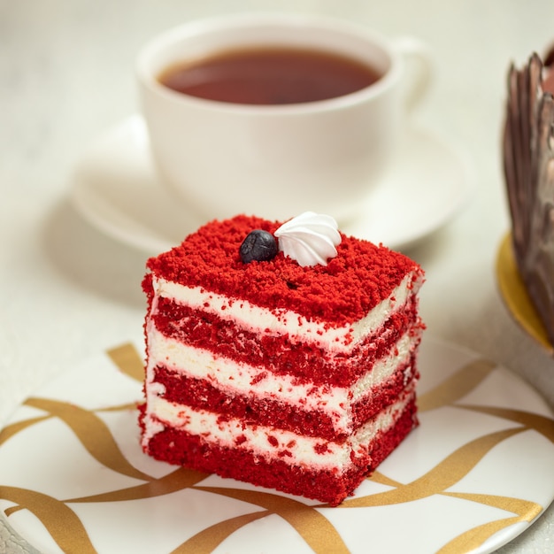 Red velvet cake with cup of tea, cake slice close up