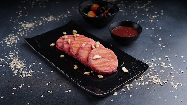 Red velvet protein pancake with strawberry and berry served in dish isolated on table top view of arabic food