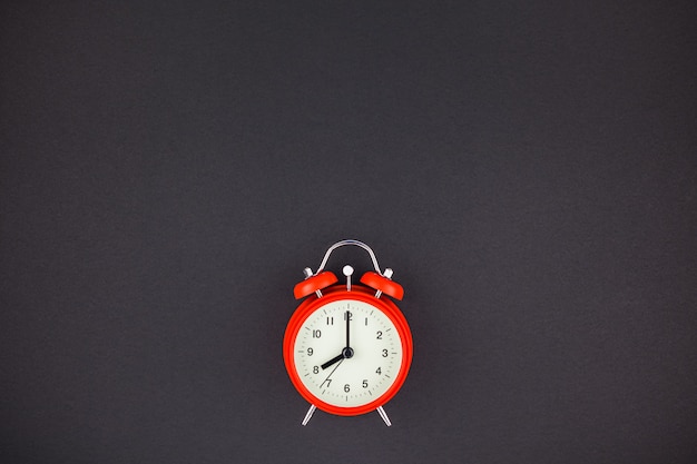 Red vintage alarm clock on dark background