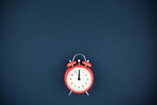 Red vintage alarm clock on dark background