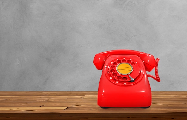 Red vintage desk phone on wooden table cement background