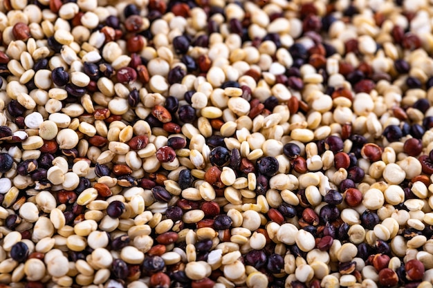 Red, white and brown quinoa seeds surface, macro closeup