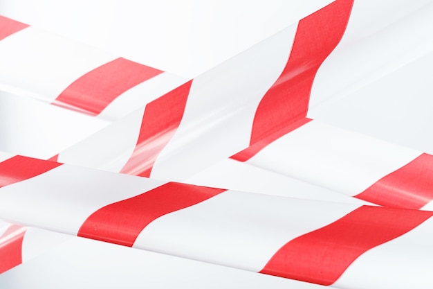 Red and white striped fencing tape on a white