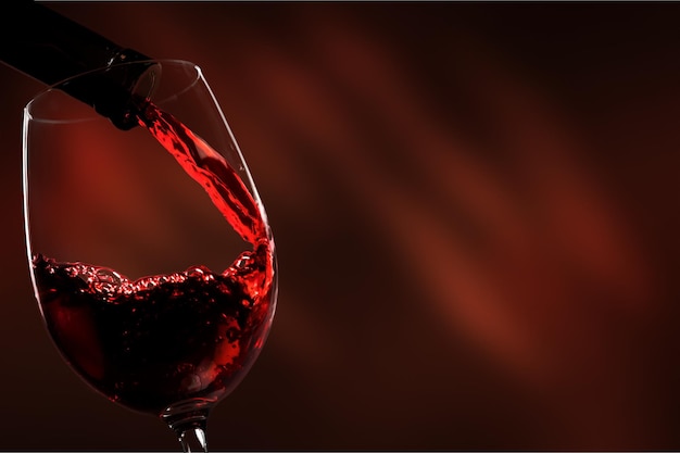 Red wine being poured in wineglass, closeup