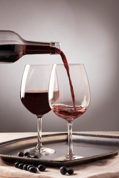 Red wine bottle pouring liquid into glass