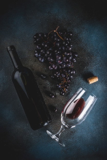 Red wine bottle with glass and grapes