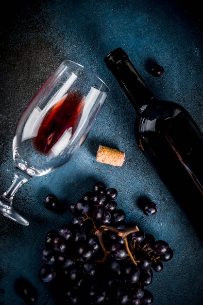 Red wine bottle with glass and grapes