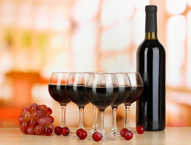 Red wine in glass and bottle on room background