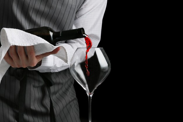 Red wine poured in glass by bartender