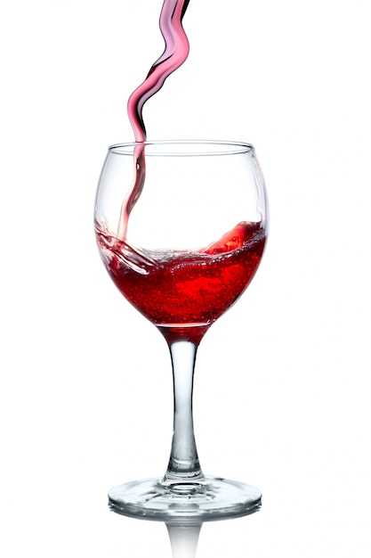 Red wine pouring in glass isolated