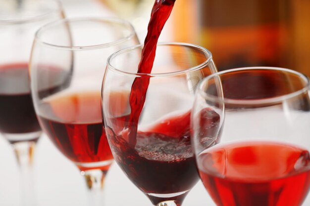 Red wine pouring into glasses closeup