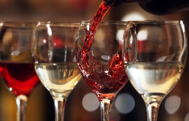 Red wine pouring into wine glass closeup