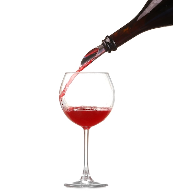 Red wine pouring into wine glass isolated