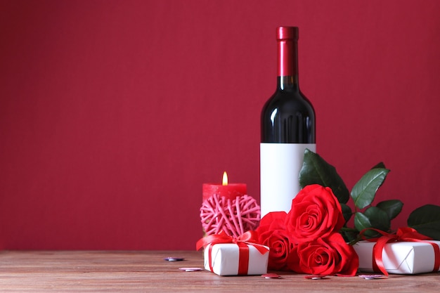 Red wine and roses on the table valentines day background