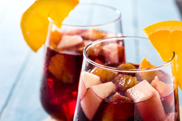 Red wine sangria in glass on blue wooden table close up