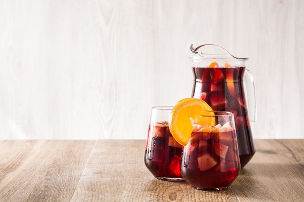 Red wine sangria in glass on wooden table copy space